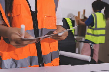 Closeup of team of industrial engineers meeting analyze machinery blueprints consult project on...