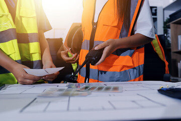 Closeup of team of industrial engineers meeting analyze machinery blueprints consult project on...