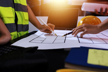 Closeup of team of industrial engineers meeting analyze machinery blueprints consult project on...