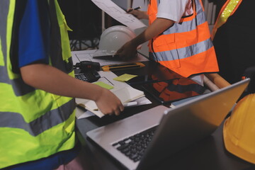 Closeup of team of industrial engineers meeting analyze machinery blueprints consult project on...