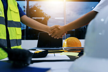 Closeup of team of industrial engineers meeting analyze machinery blueprints consult project on...
