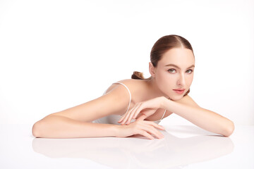 Fototapeta premium A beautiful young woman with clean, fresh skin against a white background. Skincare, facial treatment, cosmetology, beauty, and spa. An elegant portrait of an woman.