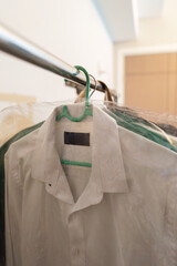 White shirt hanging with hanger on rack