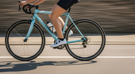 Fototapeta premium Cyclist on a light blue road bike riding on a sunny day out