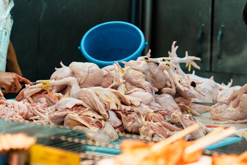 Freshly butchered chicken meat at bustling market stall