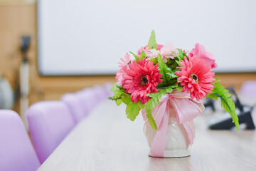 Flowers in a vase on a table in a conference room