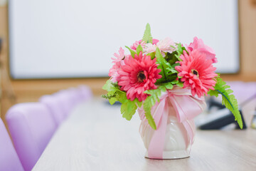 Flowers in a vase on a table in a conference room