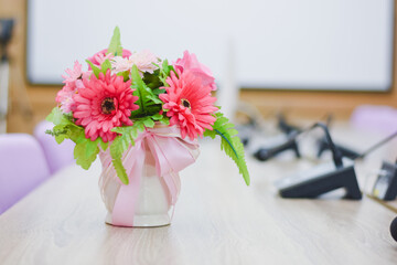 Flowers in a vase on a table in a conference room