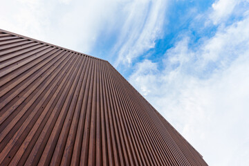 Modern brown building with vertical coated wood pattern metal steel background