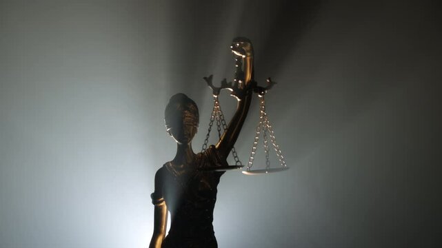 Statue of justice with scales on abstract gray background, camera zoom on slider