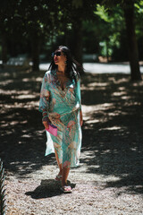 portrait of beautiful woman with long dark hair posing in the middle of the park