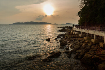Landscape with sunset at the seashore. sunset sea rock horizon view. Sea rock sunset silhouette. Sunset sea rock and mountain range. Nature background