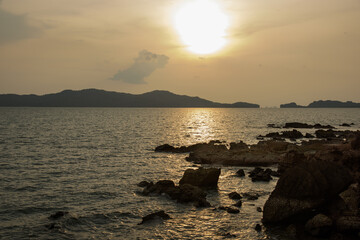 Landscape with sunset at the seashore. sunset sea rock horizon view. Sea rock sunset silhouette. Sunset sea rock and mountain range. Nature background