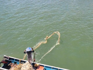 portrait of a father who works as a fisherman cleaning his nets