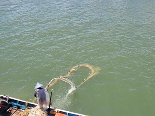 portrait of a father who works as a fisherman cleaning his nets