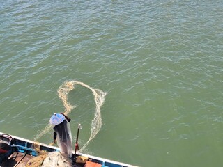 portrait of a father who works as a fisherman cleaning his nets