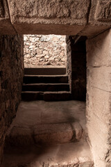 Stone steps leading to a light source in ancient ruins