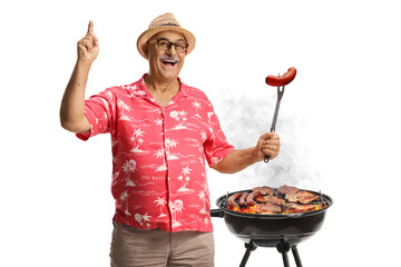 Happy mature man grilling sausages on a bbq