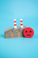 Industrial plant and sad face. Deteriorating financial situation and low expectations from...