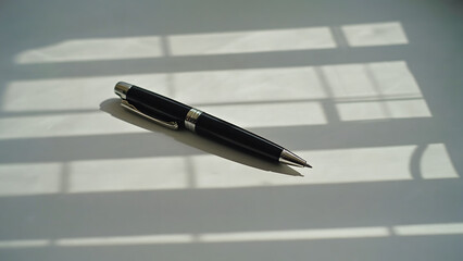 Elegant Black Pen on White Surface with Window Shadow