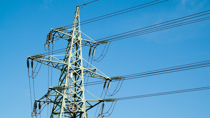 power transmission line support and wires against blue sky close-up