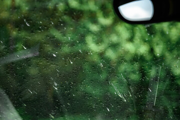 Smeared and dirty front windshield of a vehicle after hitting bugs.
