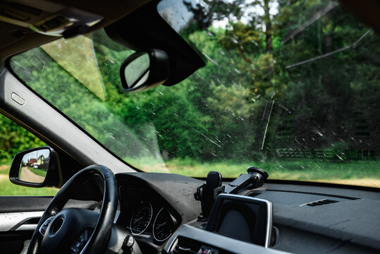 Smeared and dirty front windshield of a vehicle after hitting bugs.