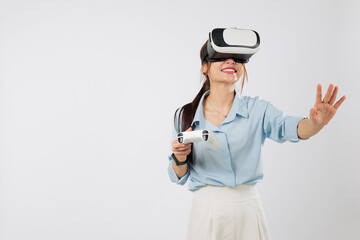 VR game fun as Young Asian woman smiles while playing VR game using joystick controller and touching virtual panel with palm in immersive reality. isolated studio white background
