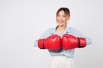 Boxing gloves raised by Asian young woman ready to fight with business pride. Strong smile and...
