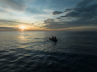 Aerial view of traditional Asian fishing boats in the middle of the ocean. Traditional Asian fishermen heading out to sea at dusk