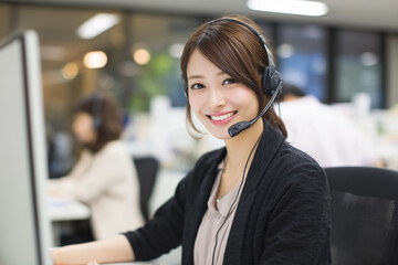 笑顔で電話対応するコールセンターの女性オペレーター