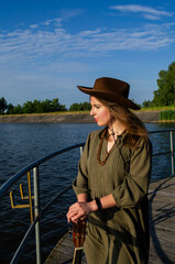 A girl with a guitar in cowboy style. Cowboy hat and boots. Sunny atmospheric photos.