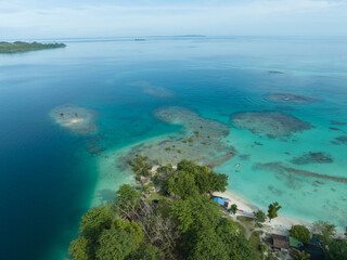 Aerial view of a beautiful tropical island in the Pacific Ocean with turquoise water. A tropical island with calm waves and clear skies