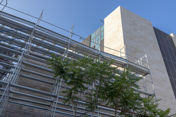 Scaffolding for cladding the exterior walls of a building under construction. Scaffolding for construction workers for the convenience of working at height.