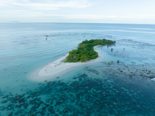 Cinematic aerial view of a beautiful small tropical island. Aerial view of a small island in the middle of a turquoise ocean