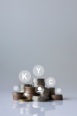 KYC compliance concept with stacked coins and digital icon overlay