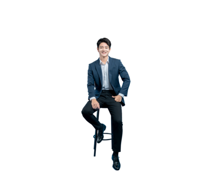 A relaxed and confident young Asian businessman sits on a stool with one hand in his pocket, smiling warmly at the camera.
 - Powered by Adobe