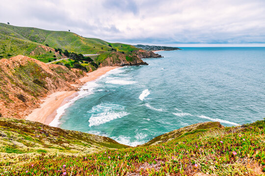 Dramatic ocean cliffs and lush coastal hills seen from Devils Bunker overlook, near Gray Whale Cove State Beach along Californias scenic Highway 1.