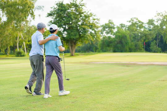 Asian man and elderly father are enjoy playing golf together with a good time.