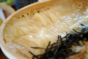 Glossy Cold Udon Noodles in a Bamboo Basket with Ice and Nori – Japanese Cuisine Close-Up