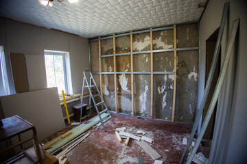 Metal frame attached to the wall with wooden bars and screws, preparing for plasterboard...