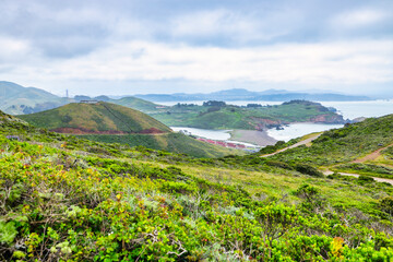 Panoramic view of Rodeo Beach, Fort Cronkhite, and lush hills of Marin Headlands near Highway 1,...