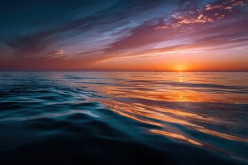 Fototapeta premium Sunset over calm ocean with vibrant colors reflecting on the water surface in a tranquil evening
