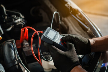 Car Mechanic Checking Battery with Diagnostic Tool