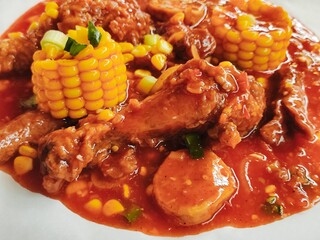 Close-up of crispy fried chicken topped with Asian sweet and spicy sauce. Added with sweet corn,...