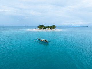 Aerial view of traditional Asian fishing boats near a small tropical island in the middle of the ocean © WarnaDunia