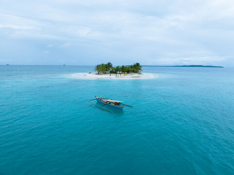 Aerial view of traditional Asian fishing boats near a small tropical island in the middle of the ocean