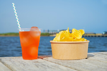 aperol spritz and some potato chips on a dock