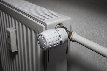White thermostatic head on the battery. Heat regulation in the house. heating season