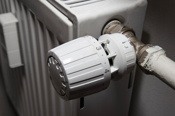 White thermostatic head on the battery. Heat regulation in the house. heating season